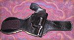 Leather ankle holster for S&W J-frame snub-nosed revolvers, shown with Model 442 gun.  Holster has sheepskin lining around leg and Velcro closure.  Maker not known.