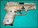SIG P228 with factory camo.  Although often advertized as &quot;desert camo,&quot; this pistol uses a hunting cammo pattern.