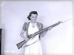 One of a series of pictures of one of the gals that worked in the Long Branch factory in Canada holding one of the finished Lee-Enfield No4Mk1* rifles.