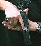 A compressed "ready" carry position used by SWAT or military personnel in tight quarters.
