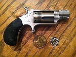 .22 Magnum NAA Mini Wasp shown in relation to a dollar coin and a dime. 