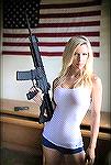 Girl holding AR and standing in front of the US Flag.